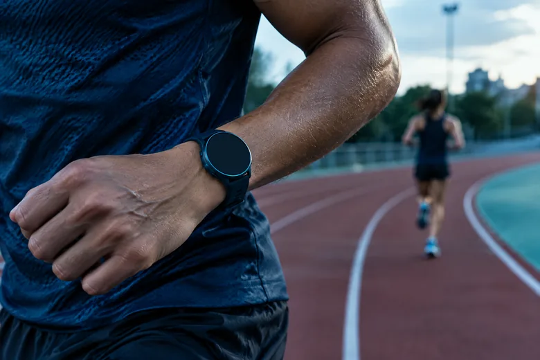 Runner wears a sensor watch during track training; editorial illustration
