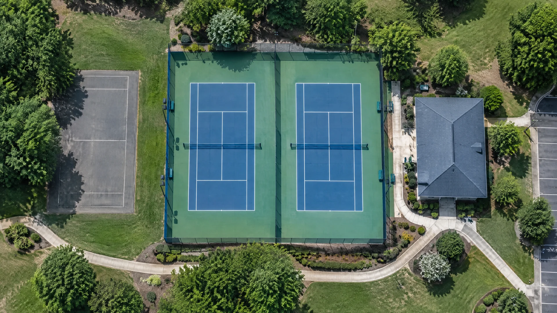 Original fictional aerial illustration of tennis courts and surrounding rectangular surfaces; not real satellite imagery, a verified location or AI detection output