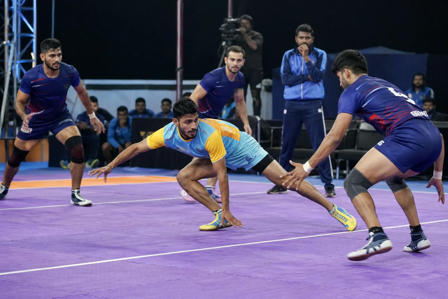 A kabaddi raider evading defenders during a coached live drill on a clearly marked kabaddi court