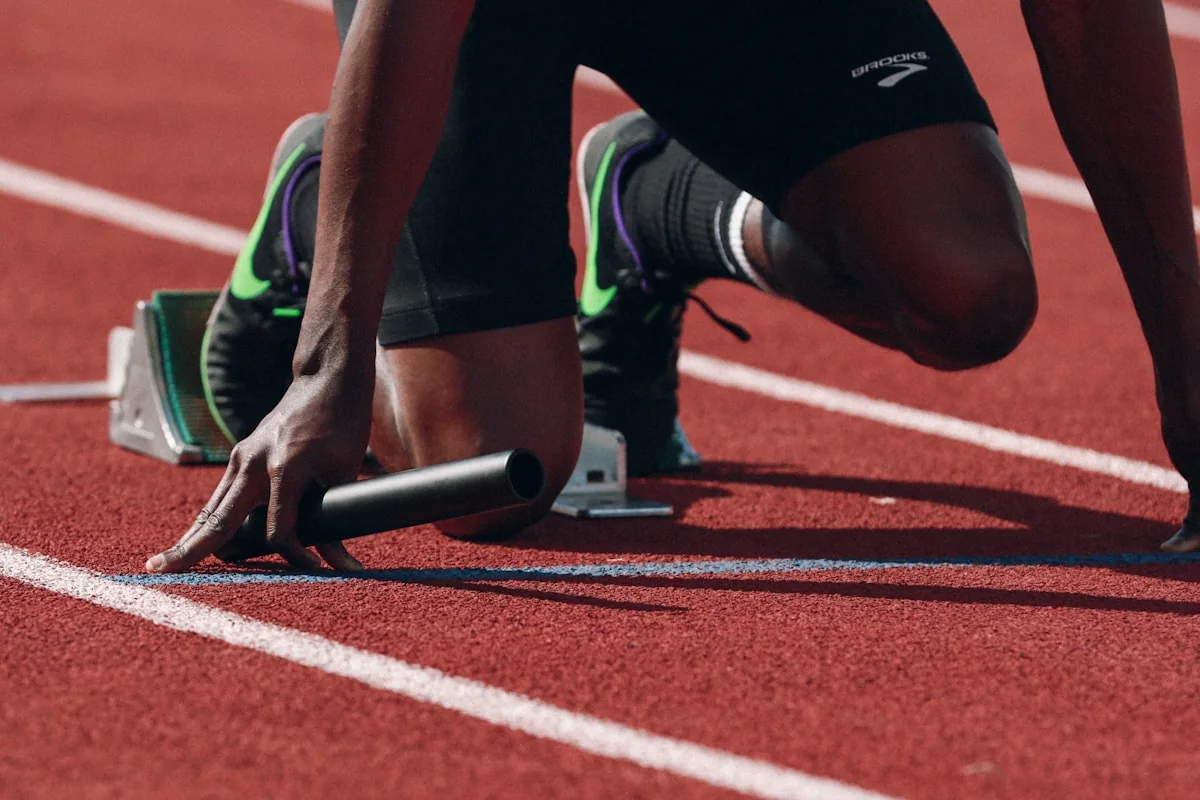 Runner training on a marked athletics track at sunset