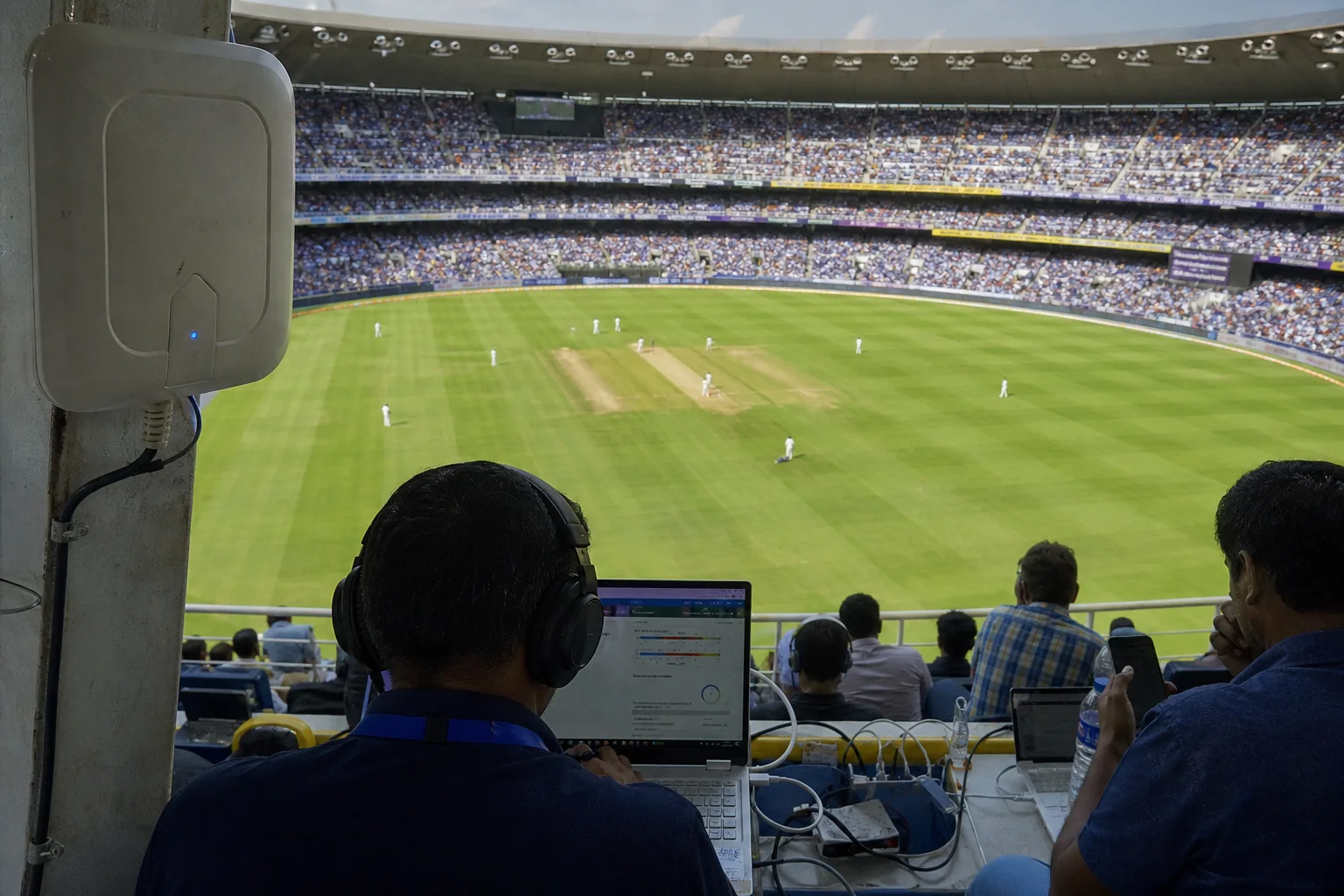 A high-angle view from a packed football or cricket stadium bowl over a clearly marked pitch, with visible Wi-Fi access points or subtle connectivity overlays
